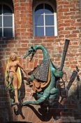 Travel photography:Dragon with maiden decorating a facade in Lübeck, Germany