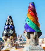 Travel photography:Sculpted chimneys on the roof of Palau Güell with MNAC in the background, Spain