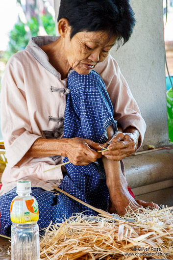 Woman cutting small pieces of wood at the Bo Sang parasol factory
