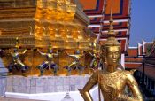 Travel photography:Golden Kinnara with demons Wat Phra Kaew in Bangkok, Thailand
