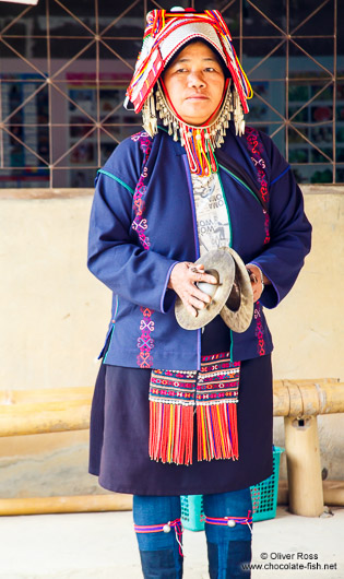 Woman in traditional dress perfoming a dance at the Ban Lorcha Akha village