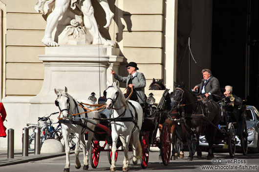 Fiakers (horse carts for tourists) entering Vienna´s  Hofburg