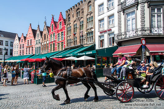 Horse carts carry tourists through Bruges