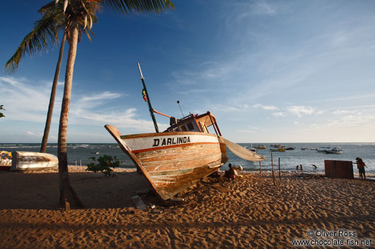 Boat on Praia do Forte beach at sunset