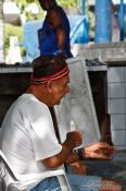 Travel photography:Copacabana fisherman mending his net, Brazil