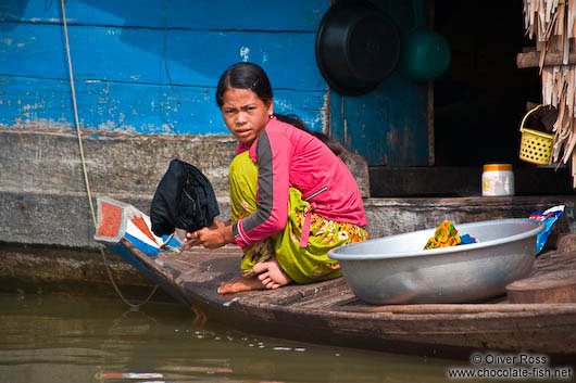 Girl doing the dishes in the Stung Sangker river