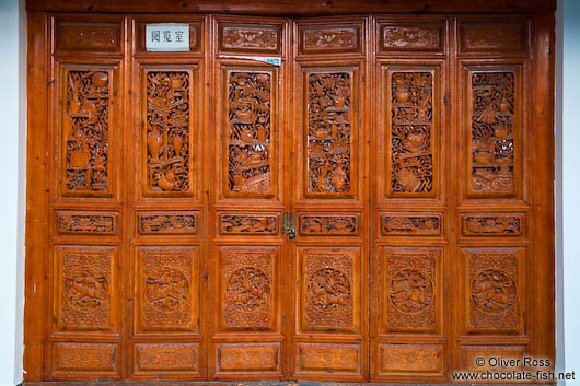 Ornate carvings on a wooden door in Dali