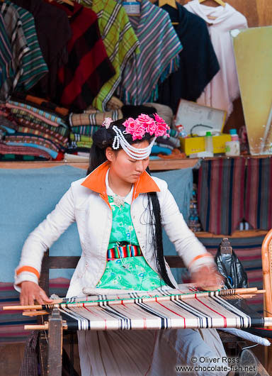 Girl with traditional Naxi dress weaving in Lijiang