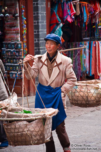 Woman carrying baskets in Lijiang