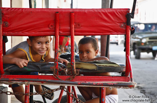Two boys playing on a cycle rickshaw in Cienfuegos