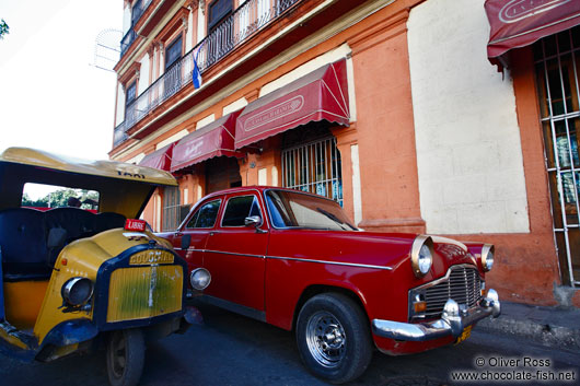 Classic car with a coco-taxi outside the Cigar Museum