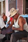 Travel photography:Man polishing shoes in Sancti-Spiritus, Cuba