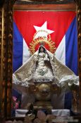 Travel photography:Maria statue with Cuban flag inside the Parroquia de San Juan Bautista de Remedios, Cuba
