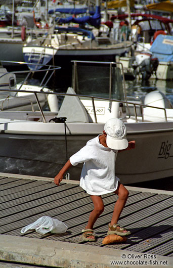 Boy feeding fish in Bonifacio, Corsica