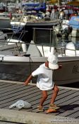 Travel photography:Boy feeding fish in Bonifacio, Corsica, France