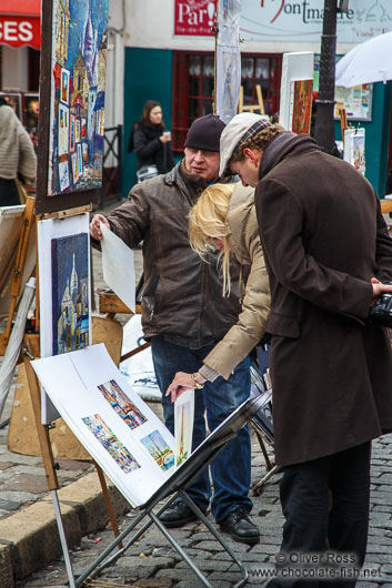 Passers-by browse through the art on offer in Paris´ Montmartre district