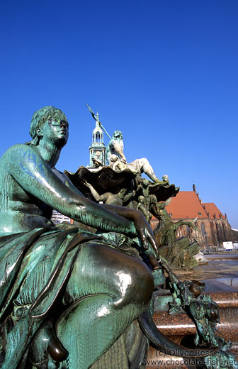 Neptunbrunnen (Neptune`s fountain) on Berlin`s Alexanderplatz with St.-Marien Kirche in the background