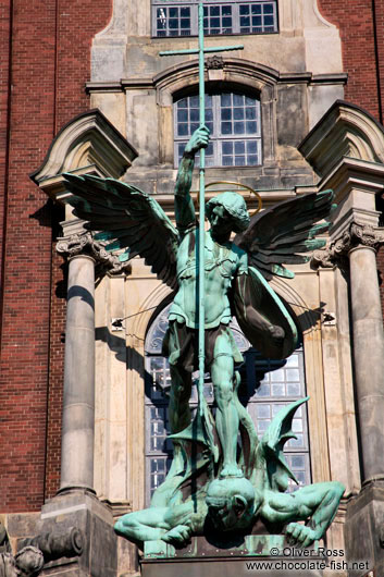 Bronze sculpture of the archangel Michael defeating the devil above the entrance portal of St. Michaelis church (Michel)