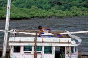 Travel photography:Having a nap on his boat at Elephanta Island near Mumbai, India