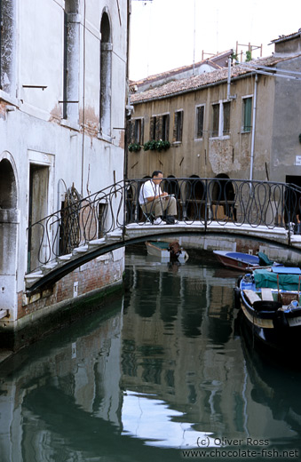 Man drawing from a bridge near Campo de la Madalena in Venice