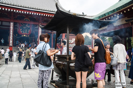 Visitors in Tokyo´s Senso-ji temple in Asakusa rub in smoke for good luck