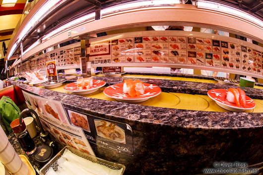 Fresh sushi arrive on a conveyor belt in a Tokyo restaurant
