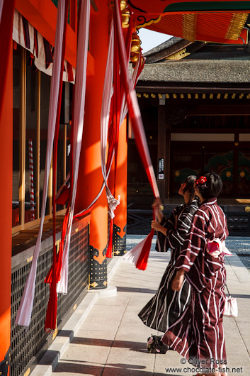 Two girls in Kimono pray at  Kyoto´s Inari shrine