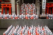 Travel photography:Small figurines of foxes at Kyoto´s Inari shrine, Japan