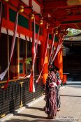 Travel photography:Two girls in Kimono pray at  Kyoto´s Inari shrine, Japan