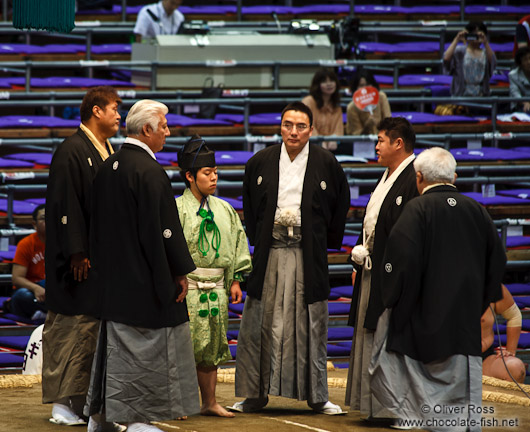 The five shimpan (judges) usually seated around the ring meet in the center to hold a mono-ii at the Nagoya Sumo Tournament