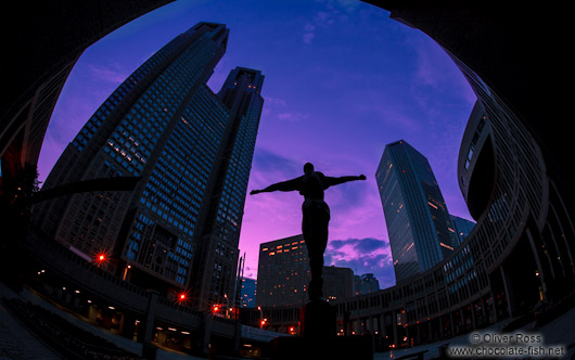 Statue with Tokyo Metropolitan Government Building in Shinjuku at sunset