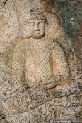 Travel photography:Image of seated Yeorae carved on rock surface at Yongjangsa in the Namsan mountains, South Korea