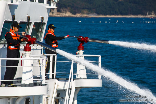 The coastguard assists local fishermen to bring out clay to mitigate the effects of a harmful algal bloom event