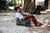 Travel photography:Chichen Itza man sitting in box, Mexico