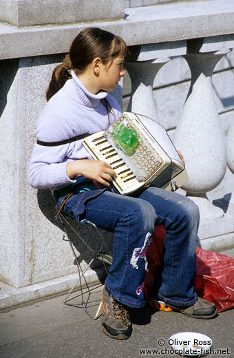Girl with accordion busking in Ljubljana
