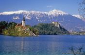 Travel photography:Island with church and Bled Castle with Blejsko jezero (Bled lake) and the Slovenian Alps in the background, Slovenia