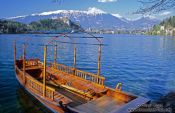 Travel photography:Boat in Blejsko jezero (Bled lake) with Bled Castle in the background, Slovenia