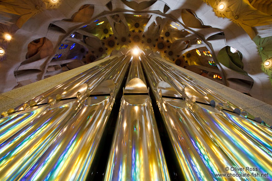 Colourful light from the stained glass windows is reflected off the organ pipes in the Sagrada Familia