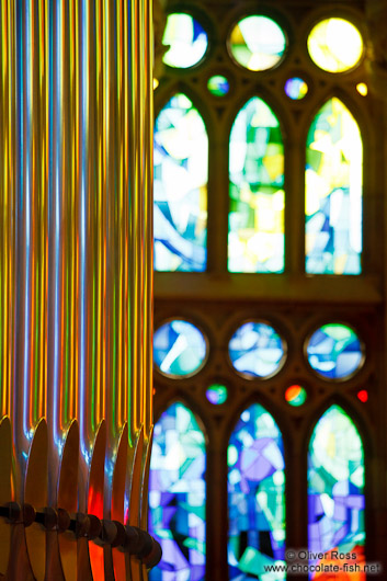 Colourful light from the stained glass windows is reflected off the organ pipes in the Sagrada Familia