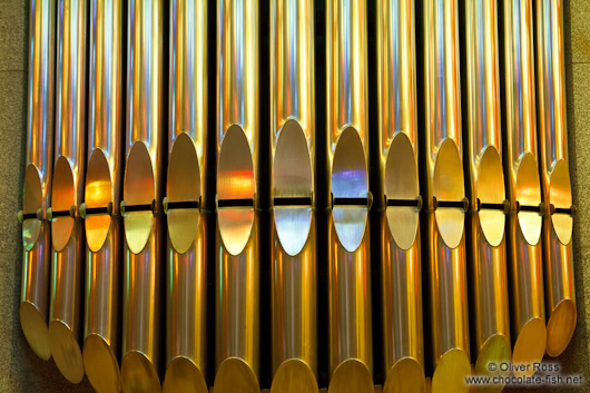 Colourful light from the stained glass windows is reflected off the organ pipes in the Sagrada Familia