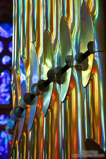 Colourful light from the stained glass windows is reflected off the organ pipes in the Sagrada Familia