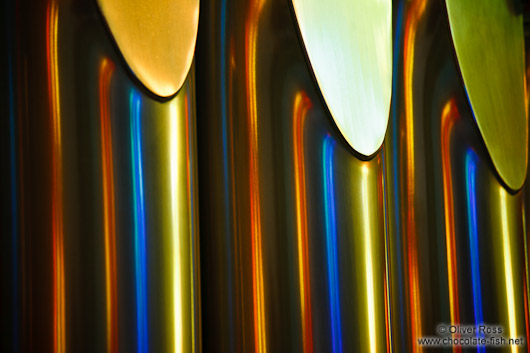 Colourful light from the stained glass windows is reflected off the organ pipes in the Sagrada Familia