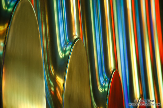 Colourful light from the stained glass windows is reflected off the organ pipes in the Sagrada Familia