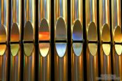 Travel photography:Colourful light from the stained glass windows is reflected off the organ pipes in the Sagrada Familia, Spain