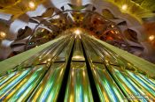 Travel photography:Colourful light from the stained glass windows is reflected off the organ pipes in the Sagrada Familia, Spain