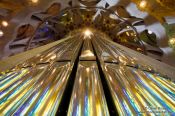Travel photography:Colourful light from the stained glass windows is reflected off the organ pipes in the Sagrada Familia, Spain
