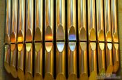 Travel photography:Colourful light from the stained glass windows is reflected off the organ pipes in the Sagrada Familia, Spain