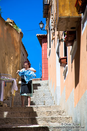 Toledo woman hanging clothes in street