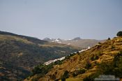 Travel photography:View of Capileira village with snow capped Pico Veleta in the background, Spain