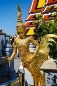 Travel photography:Golden Kinnara statue at Wat Phra Kaew, the Bangkok Royal Palace, Thailand